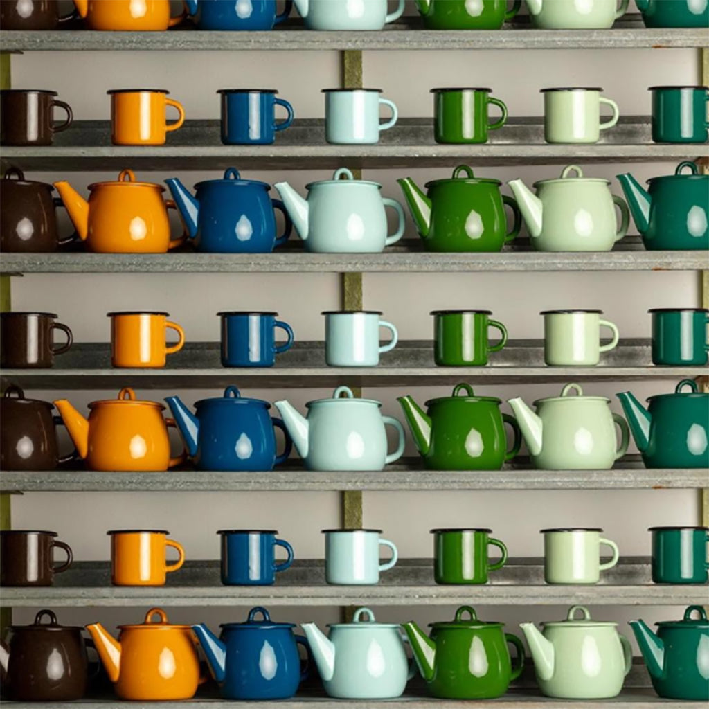 Shelves filled with colorful enamel teapots and enamel mugs